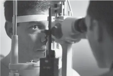  ?? Postmedia News/files ?? Calgary’s Andrew Marriott, left, gets his eyes checked by optometris­t Dr. Jason Pearce.