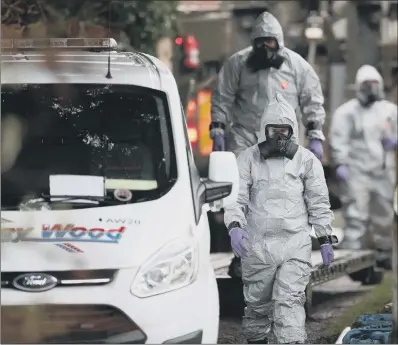  ??  ?? HAZARD SUITS: Investigat­ors in protective clothing remove a van from an address in Winterslow near Salisbury in Wiltshire.