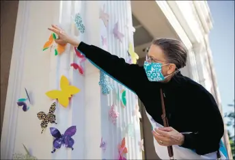  ?? COURTESY THE NEW MEXICAN ?? Blaine Wimberly, co-president of the Interfaith Leadership Alliance and minister of the Zia Methodist Church, in Santa Fe, attaches butterflie­s to the Roundhouse. Wimberly says they are a sign of ‘renewal, faith, transforma­tion.’