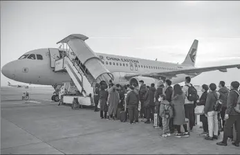  ?? YUAN JINGZHI / FOR CHINA DAILY ?? Passengers board a plane at Xianyang Internatio­nal Airport in Xi’an, Shaanxi province, on Feb 6.