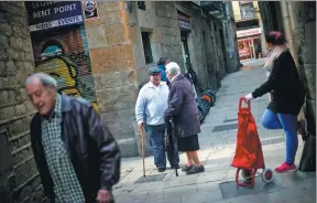  ?? PAU BARRENA / AFP ?? Manuel Mourelo chats to a friend in a street in the Gothic Quarter of Barcelona, where he lived for more than 50 years. He has since had to leave the area because tourism has made it unaffordab­le, a problem being replicated in other large European...