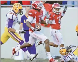  ?? (Arkansas Democrat-Gazette file photos) ?? Cobi Hamilton of Arkansas runs into the end zone past LSU defenders Eric Reid (1) and Patrick Peterson (7) for one of his two long touchdown receptions in the first half against LSU. Hamilton finished with 3 receptions for 164 yards and 2 touchdowns.