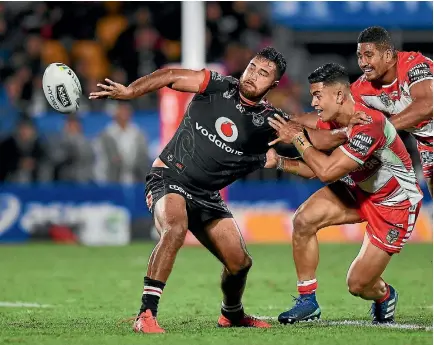  ?? PHOTO: PHOTOSPORT ?? Peta Hiku gets an offload away against the Dragons. The Warriors centre believes competitiv­eness within the squad will hold the side in good stead.