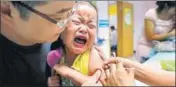  ??  ?? A child being vaccinated at a health station in central China.