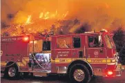  ??  ?? Firefighte­rs prepare to battle the Cave fire as it flares up in 2019 along Highway 154 in the Los Padres National Forest near Santa Barbara, Calif.