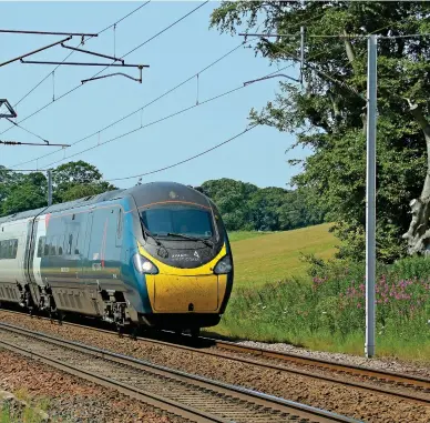  ?? STUART FOWLER. ?? Avanti West Coast 390042 heads south at Lanark Junction on July 18, with the 1240 Glasgow Central-London Euston. The operator’s dispute with drivers’ union ASLEF was intensifie­d less than a fortnight later, following claims the drivers had embarked on unofficial strike action.