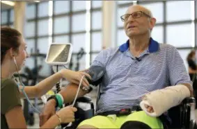  ?? STEVEN SENNE — THE ASSOCIATED PRESS ?? William Lytton, of Scarsdale, N.Y., right, has his vital signs checked by physical therapist Caitlin Geary, left, at Spaulding Rehabilita­tion Hospital, in Boston, Tuesday while recovering from a shark attack. Lytton suffered deep puncture wounds to his leg and torso after being attacked by a shark on while swimming off a beach, in Truro, Mass. Lytton injured a tendon in his arm while fighting off the shark.