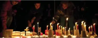  ?? JONATHAN HAYWARD/THE CANADIAN PRESS ?? People place candles during a memorial for Amanda Todd in Surrey, B.C., in October. People in more than 40 cities paid tribute to the teen, who took her own life in the wake of cyberbully­ing.