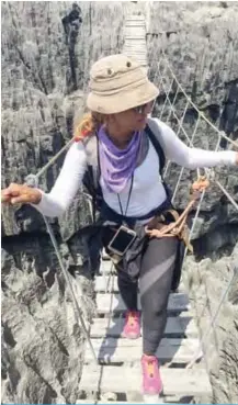  ??  ?? Fatma Al-Mattar crosses a bridge during an adventure in Madagascar.