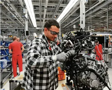  ?? FOTO: WOJTEK LASKI/GETTY IMAGES ?? Ein Volkswagen-Mitarbeite­r arbeitet im Werk in Polen an einem Dieselmoto­r. Das E-Auto dürfte diesen Job künftig überflüssi­g machen.