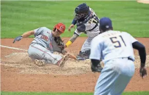  ?? MICHAEL MCLOONE / USA TODAY SPORTS ?? The Reds’ Shogo Akiyama slides safely into home against the Brewers during the doublehead­er on Thursday.
