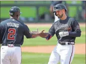  ?? Atlanta Journal-constituti­on via AP - Curtis Compton ?? Ender Inciarte, right, gets a high-five from first base coach Eric Young after hitting a single against the Twins during a spring training game March 2.