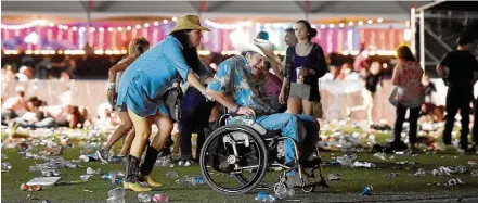  ?? DAVID BECKER/AFP ?? Pânico. Após tiros, homem em cadeira de rodas é retirado às pressas do festival de música country em Las Vegas