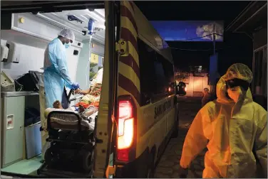  ??  ?? Yahya Niane (left), Mobile Emergency Care Service doctor helps Binta Ba before transferri­ng her to the hospital in Dakar.