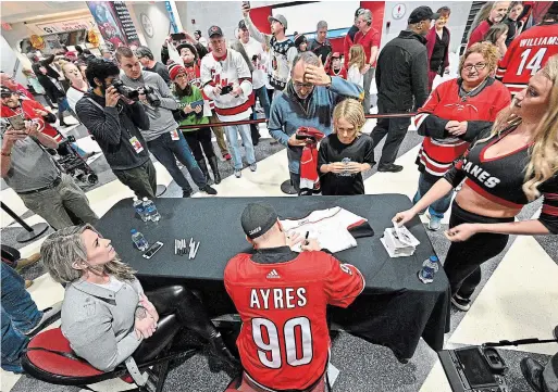  ?? GRANT HALVERSON TNS ?? Dave Ayres signs autographs for fans during the game between the Dallas Stars and Carolina Hurricanes at PNC Arena on Feb. 25 in Raleigh, N.C.