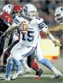  ?? JEFF MCINTOSH/THE CANADOAN PRESS ?? Toronto Argonauts’ quarterbac­k Ricky Ray, right, runs from Calgary Stampeders’ players during second half CFL football action in Calgary, on Saturday.