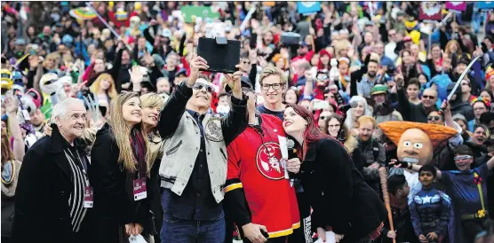  ?? PHOTOS: RYAN MCLEOD ?? Calgary-born comic-book creator Todd McFarlane, his family, Calgary Mayor Naheed Nenshi and Emily Expo pose for a selfie with the massive crowd at Olympic Plaza.