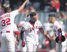  ?? ASHLEY LANDIS — THE ASSOCIATED PRESS ?? The Angels’ Juan Lagares, center, celebrates with Raisel Iglesias, left, and Jose Iglesias after hitting a walk-off double during the ninth inning Sunday against Baltimore.