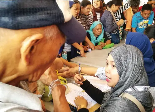  ?? SUNSTAR FOTO / ARNI ACLAO ?? AWAY FROM HOME. Marawi refugees gathered this week at Cebu City Hall to claim their assistance (25 kilos of rice for each family). It was nearly 7 months ago when the siege of Marawi began and less than 2 months ago when government authoritie­s declared...