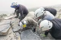  ?? JEAN-BERNARD CARON THE CANADIAN PRESS ?? A Royal Ontario Museum fieldwork crew are seen extracting a shale slab containing a fossil of Titanokory­s gainesi in the mountains of Kootenay National Park, B.C.