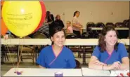  ??  ?? Sue Cluck, left, and Jamie Curtis, were giving away free toothpaste and toothbrush­es at last week’s bonanza. They also were setting up appointmen­ts with Dr. Daniel Beavers for a back to school checkup.