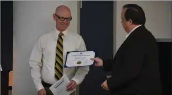  ?? Brennon Dixson/The Signal ?? Saugus Union School District board President Christophe­r Trunkey, right, gives a certificat­e to Kyle Evans in honor of Evans being the school district’s 2018 Teacher of the Year. Evans teaches at Cedarcreek Elementary.