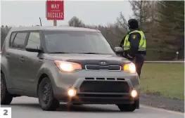  ??  ?? 2 2. Un agent de la police provincial­e de l’Ontario pose des questions à cet automobili­ste.