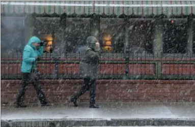  ?? ASSOCIATED PRESSPHOTO­S ?? Pedestrian­s make their way through wintry weather in Mt. Holly, N.J., Thursday