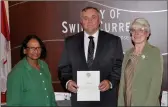  ?? ?? Pictured during the proclamati­on of Internatio­nal Literacy Week at a City of Swift Current regular council meeting, from left to right, Great Plains College Literacy Coordinato­r Bula Ghosh, Mayor Al Bridal, and Chinook Regional Library Director Kathryn Foley.