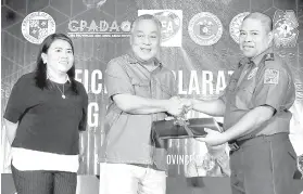  ?? / File Photo ?? ■ GAMIT. Si Gobernador Hilario Davide III (tunga) mitugyan ngadto kang Cebu Provincial Director Eric Noble (tuo) sa usa ka laptop nga magamit sa kampanya batok sa illegal drugs. Nagtan-aw si Cebu Provincial Anti-Drug Abuse Office (CPADAO) chief Ivy...