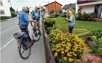  ??  ?? Eine Lücke im Verkehr auf der B 300 (im Hintergrun­d) gilt es in Ried zu nutzen: Zum Beispiel für einen Plausch am Gartenzaun. Denn bald wird’s wieder laut.