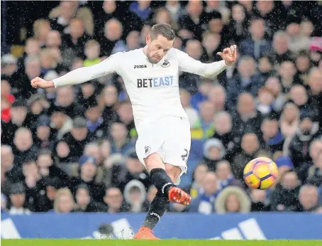  ??  ?? > Swans talisman Gylfi Sigurdsson, pictured striking a free-kick against Chelsea