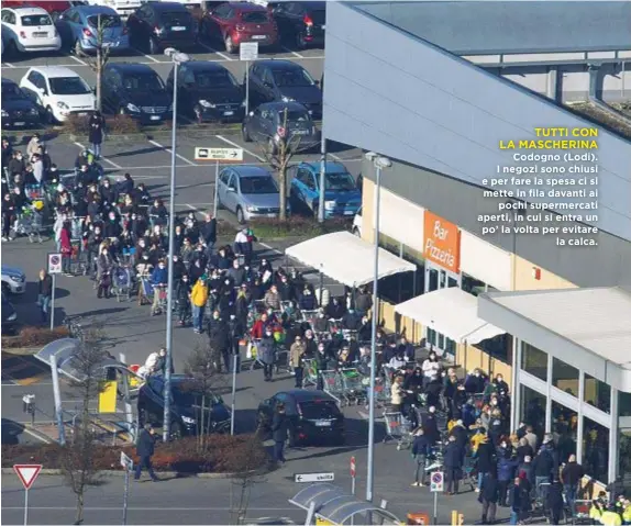  ??  ?? TUTTI CON LA MASCHERINA Codogno (Lodi). I negozi sono chiusi e per fare la spesa ci si mette in fila davanti ai pochi supermerca­ti aperti, in cui si entra un po’ la volta per evitare la calca.