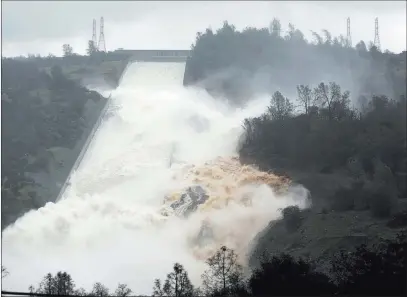  ?? Rich Pedroncell­i ?? Water rushes through a break in the wall of the Oroville Dam spillway in Oroville, Calif, on Feb. 9, 2017. The Associated Press