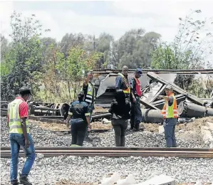  ?? / THULANI MBELE ?? A SAPS forensic team sifts through the remains of charred coaches at the site of a train crash in Kroonstad, Free State.