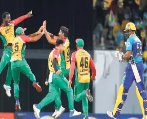  ?? AP ?? Members of the Guyana Amazon Warriors (left) celebrate the wicket of Kieron Pollard (right) of the Barbados Tridents on Match 25 in the 2017 Hero Caribbean Premier League at Kensington Oval on Tuesday night. Third from right is bowler Sohail Tanvir who...