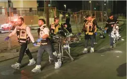  ?? MAHMOUD ILLEAN/AP ?? A rescue and recovery team removes a body after a deadly shooting attack Friday night near a Jerusalem synagogue while the Jewish Sabbath was being celebrated.