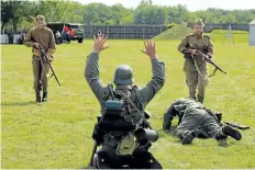  ?? ALLAN BENNER/STANDARD STAFF ?? Re-enactors playing German soldiers surrender to Russian troops during the Echoes of Niagara's Past event at Fort George on Sunday.