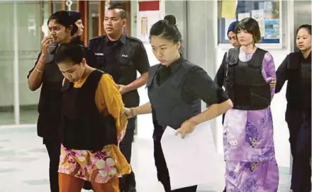  ?? PIC BY ROSLIN MAT TAHIR ?? Doan Thi Huong (second from right) and Siti Aisyah (second from left) being led out of the Shah Alam High Court yesterday.