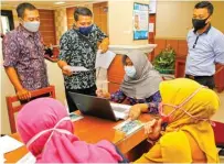  ?? DIPTA WAHYU/JAWA POS ?? BERI INFORMASI: Petugas Dispendik Jatim membantu wali murid mengakses website PPDB di kantor Dinas Pendidikan Provinsi Jawa Timur.