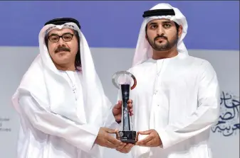  ??  ?? Sheikh Maktoum bin Mohammed bin Rashid Al Maktoum, Deputy Ruler of Dubai, and the Chairman of Dubai Media Incorporat­ed, hands an award to Nasser Al Dhaheri