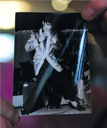  ?? NICK PROCAYLO ?? Rob Frith holds one of the photos of Elvis Presley onstage at Empire Stadium on Aug. 31, 1957. “That’s just killer! It’s the classic pose,” says Frith, who owns Neptoon Records on Main Street.