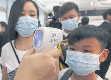  ??  ?? A boy gets his temperatur­e checked as he arrives at Suvarnabhu­mi airport in Bangkok during the Mers (Middle East Respirator­y Syndrome) outbreak in the region 2015.