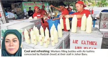  ??  ?? Cool and refreshing: Workers filling bottles with Air kathira concocted by Radziah (inset) at their stall in Johor Baru.