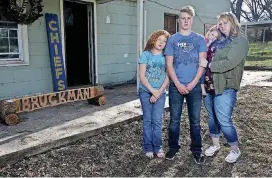  ?? [PHOTO BY MIKE SIMONS, TULSA WORLD] ?? The Bruckmans pose for a portrait March 30 in the front yard of their home. Husband and father William Bruckman, was killed during a pursuit on U.S. 75 when he was hit head-on by a stolen truck that was pursued by several law enforcemen­t agencies...