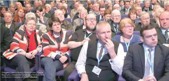  ?? — Reuters ?? Delegates listen to Britain’s Prime Minister, Theresa May (right), address the Conservati­ve Party’s Scottish conference in Glasgow on Friday.