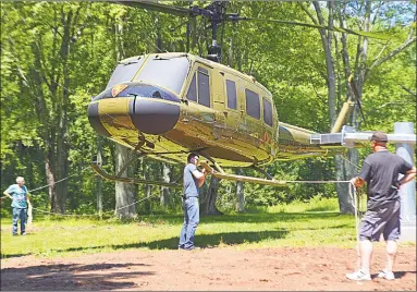  ?? Cassandra Day / Hearst Connecticu­t Media ?? Members and supporters of the Greater Middletown Military Museum gathered on Friday at Veterans Park to watch a giant crane lift a Lao Special Guerrilla Unit Helicopter onto a pedestal.