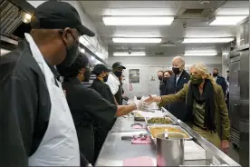  ?? SUSAN WALSH — THE ASSOCIATED PRESS ?? President Joe Biden, first lady Jill Biden, Vice President Kamala Harris, and second gentleman Doug Emhoff, arrive to assemble Thanksgivi­ng meal kits during a visit to DC Central Kitchen in Washington on Tuesday.