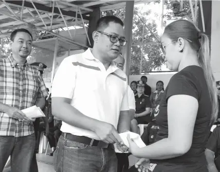  ?? KRISTINE JOYCE W. CAMPAÑA ?? Michelle Candano, the wife of PO1 Windel Llano Candano, one of the fallen SAF commandos, receives cash aid from Alta Vista Golf and Country Club which was represente­d by its General Manager Nimrod Quiñones. Cebu Country Club and the Regional Advisory...