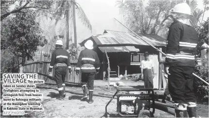  ??  ?? This picture taken on Sunday shows firefighte­rs attempting to extinguish fires from houses burnt by Rohingya militants at the Maungdaw township in Rakhine State in Myanmar. VATICAN CITY: